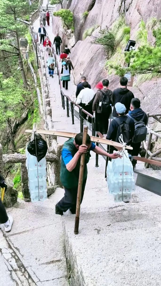 男子爬黄山把老婆扛在肩上