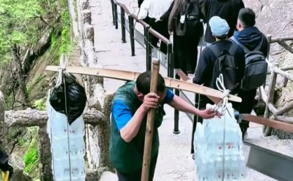 男子爬黄山把老婆扛在肩上