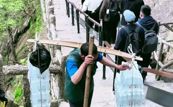 男子爬黄山把老婆扛在肩上